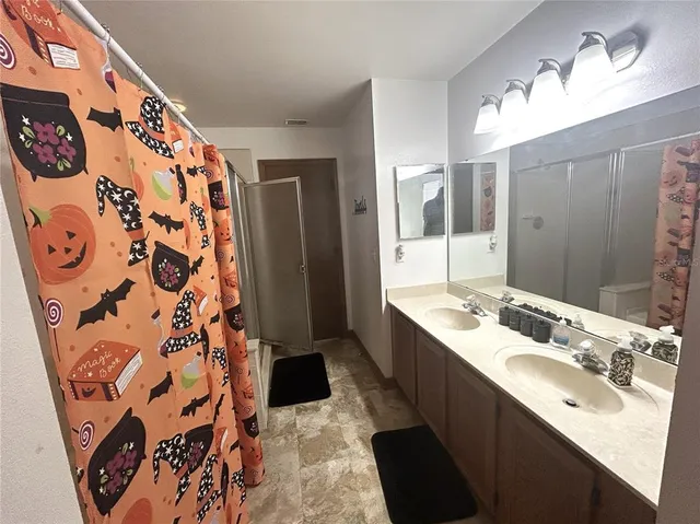 a bathroom with a sink and mirror with shower
