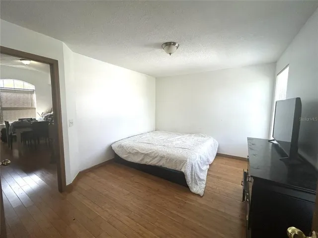 a bedroom with a bed and wooden floor