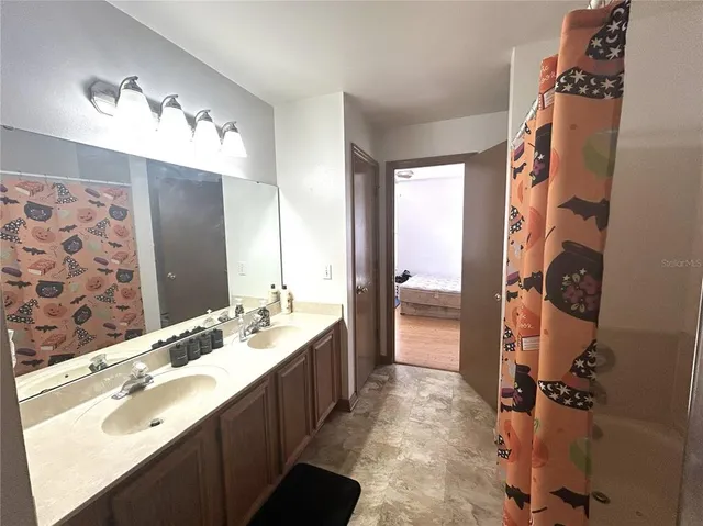 a bathroom with a sink and mirror with shower