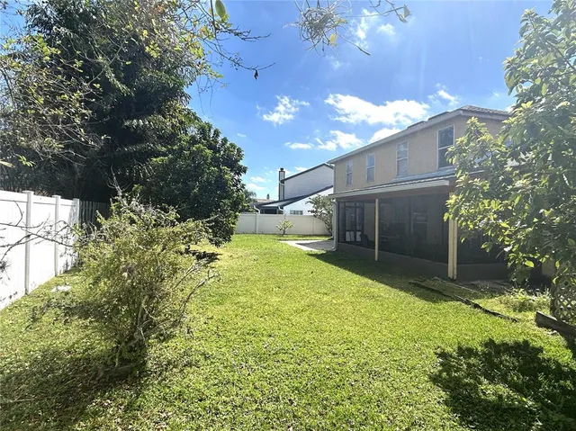 a view of a house with a yard and tree s