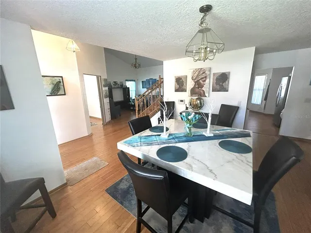 a dining room with furniture a chandelier and wooden floor