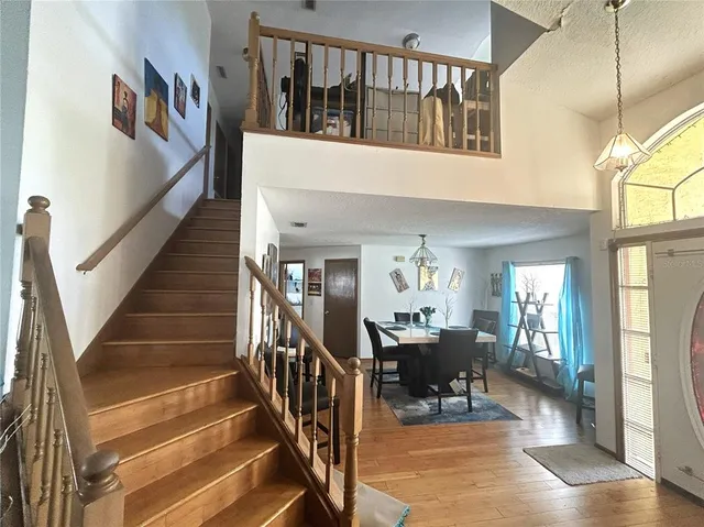 a view of a hallway with dining room and wooden floor