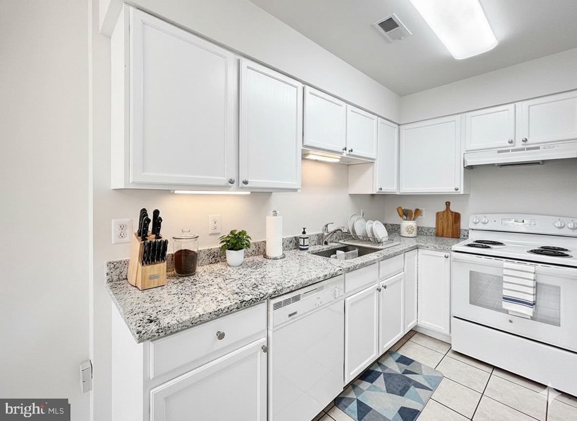 102 Crossbill Way Frederick, MD 21702 - Photo 3 of 16 a kitchen with granite countertop a sink stainless steel appliances white cabinets and a window