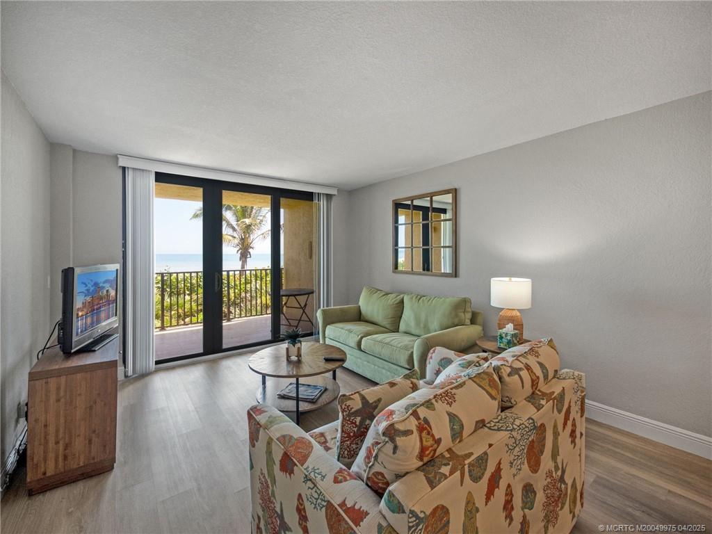 7380 South Ocean Drive, Unit 220 Jensen Beach, FL 34957 - Photo 11 of 33 a living room with furniture and a flat screen tv