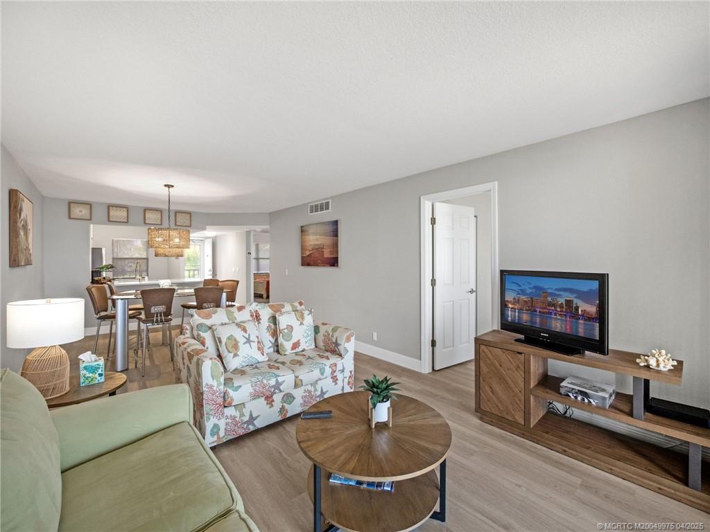 7380 South Ocean Drive, Unit 220 Jensen Beach, FL 34957 - Photo 12 of 33 a living room with furniture and a flat screen tv