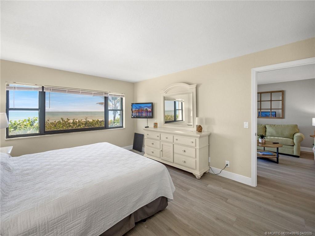 7380 South Ocean Drive, Unit 220 Jensen Beach, FL 34957 - Photo 14 of 33 a bedroom with a bed and wooden floor