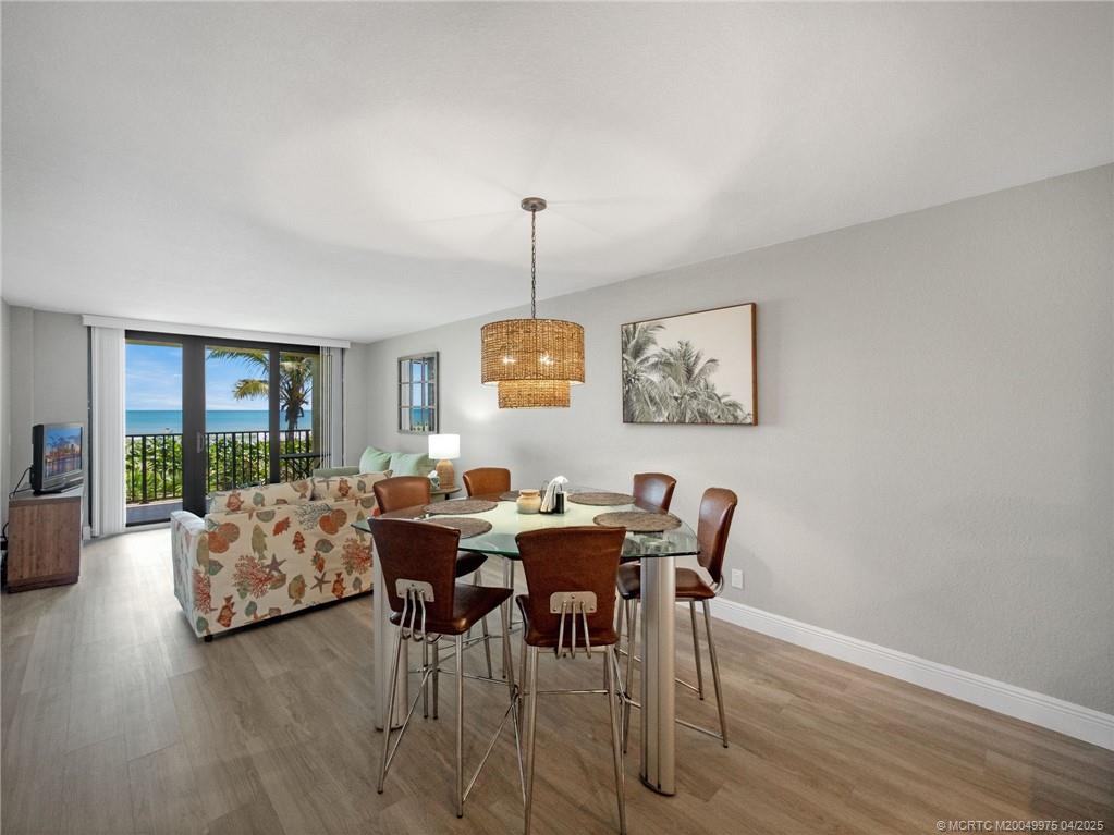 7380 South Ocean Drive, Unit 220 Jensen Beach, FL 34957 - Photo 8 of 33 a view of a dining room with furniture window and wooden floor