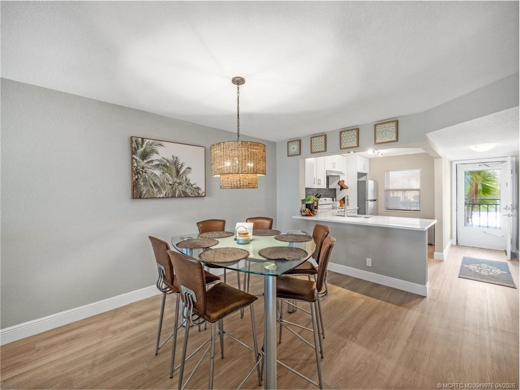 7380 South Ocean Drive, Unit 220 Jensen Beach, FL 34957 - Photo 9 of 33 a view of a dining room with furniture wooden floor and chandelier
