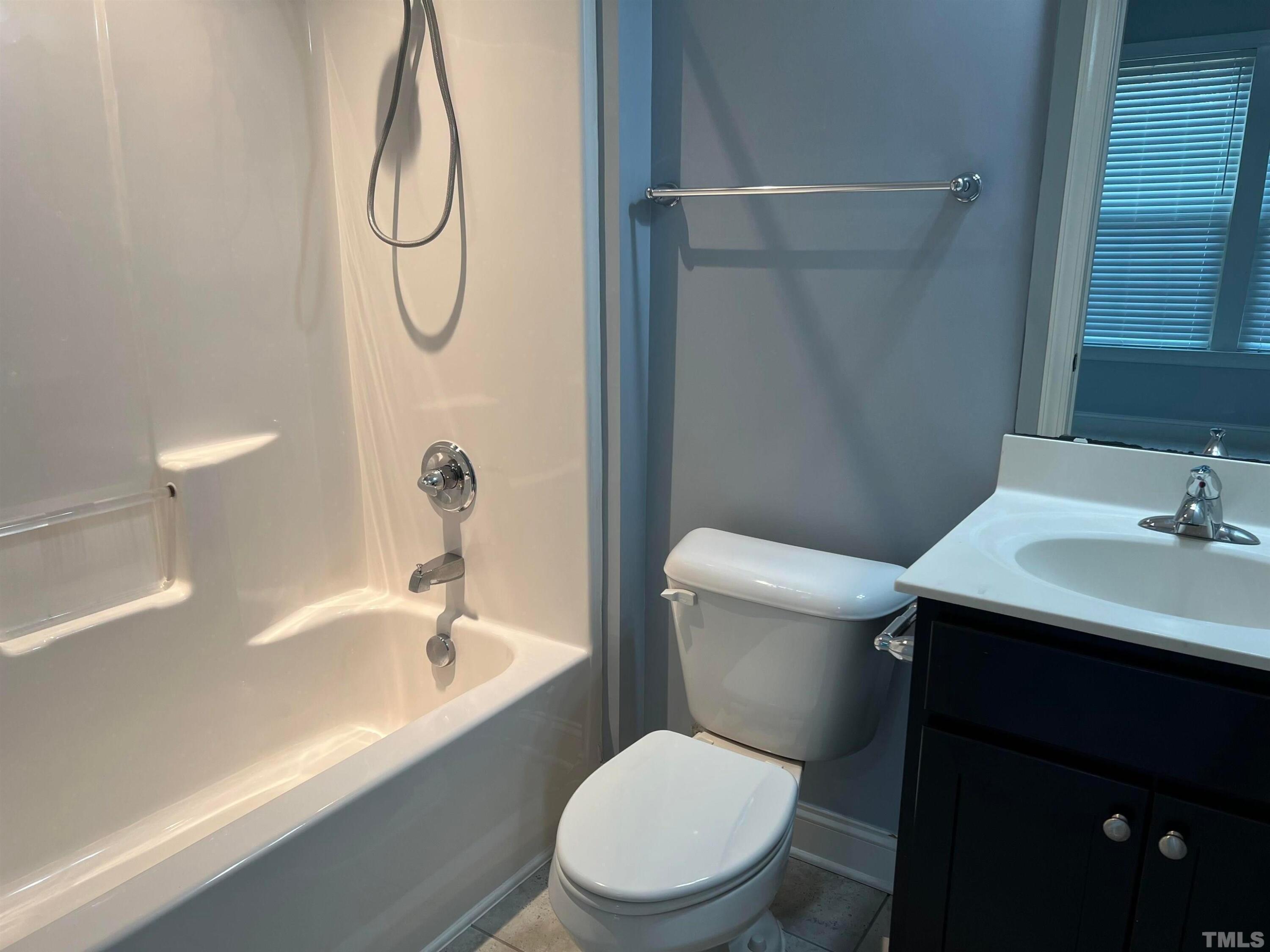 121 Red Bark Court Apex, NC 27539 - Photo 11 of 24 a white toilet sitting next to a bathroom sink and a shower