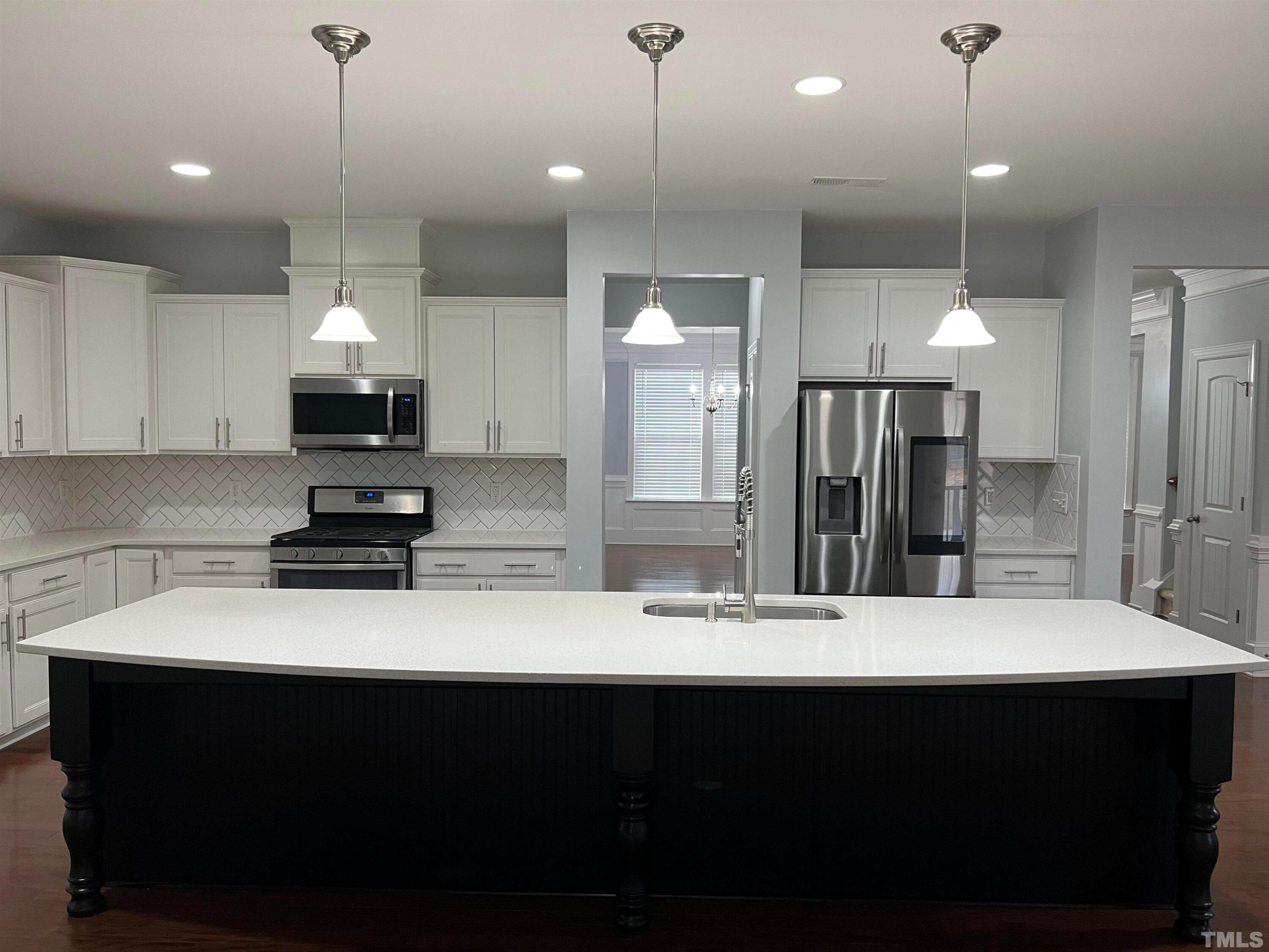 121 Red Bark Court Apex, NC 27539 - Photo 8 of 24 a kitchen with kitchen island a sink stainless steel appliances and cabinets