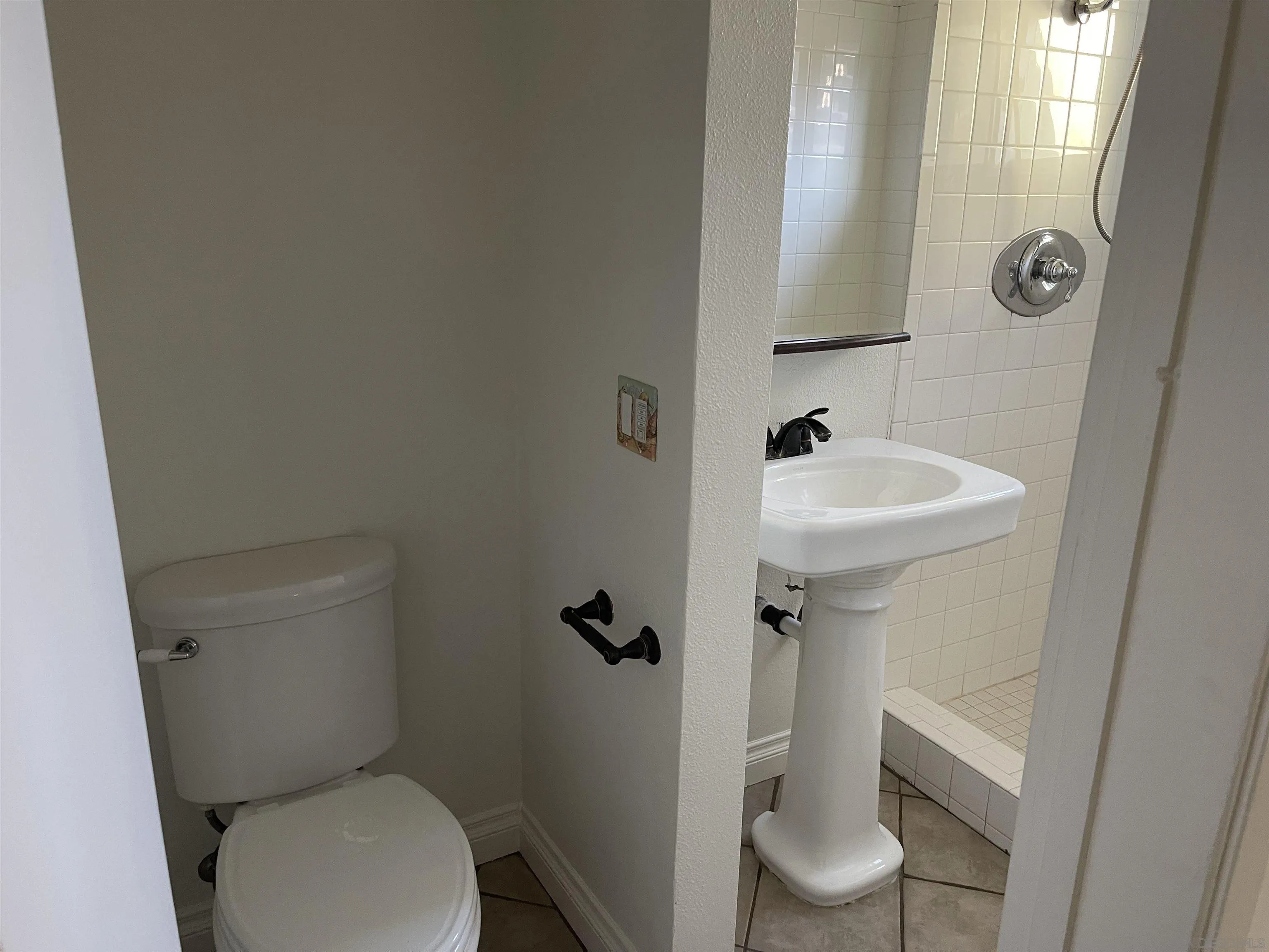 3246 Sweetwater Road Lemon Grove, CA 91945 - Photo 10 of 13 a white toilet sitting next to a bathroom sink