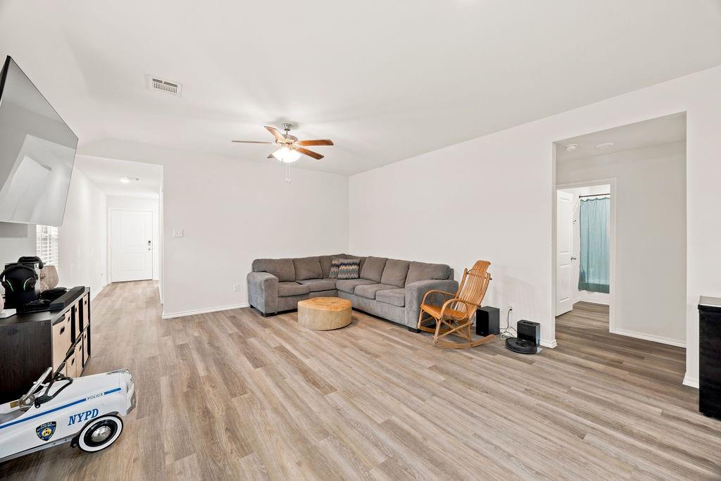 822 Ramble Road Lavon, TX 75166 - Photo 14 of 35 Spacious interior showcasing wood-finish flooring throughout, bright white walls, and an overhead ceiling fan