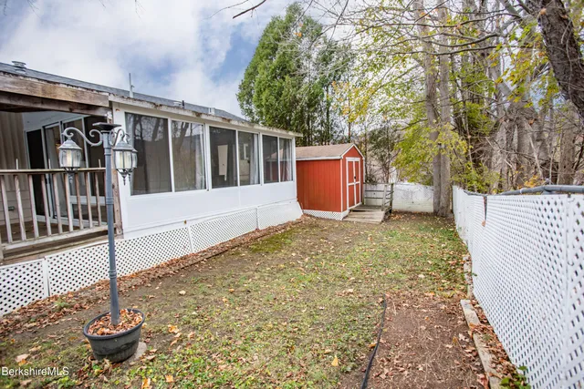 a view of house with a large window and wooden fence