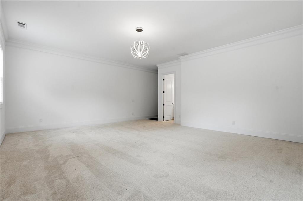 2415 West Rugby Avenue Atlanta, GA 30337 - Photo 25 of 40 an empty room with a chandelier fan and windows