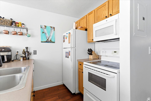 161 25th Street, Unit 6B Ogden, UT 84401 - Photo 8 of 20 Galley kitchen featuring light wood cabinetry, white appliances, wood-finish flooring, and a double basin sink