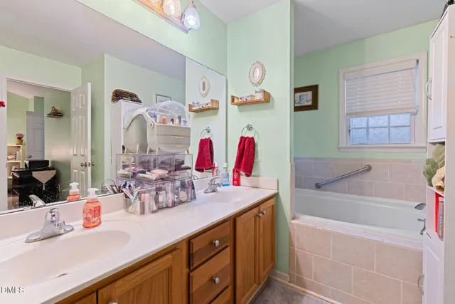 a bathroom with a sink vanity tub and a mirror