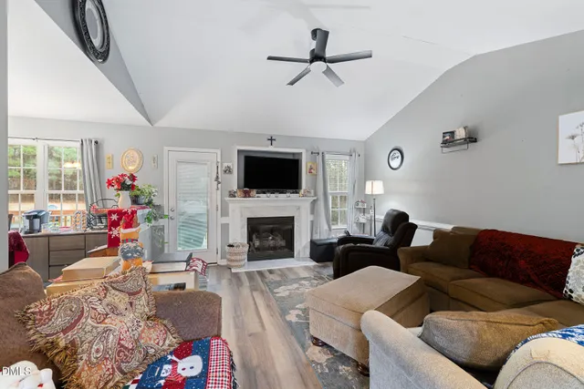 a living room with furniture a flat screen tv and a fireplace