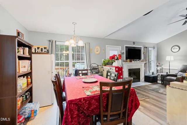 a view of a dining room with furniture a floor to ceiling window and a flat screen tv