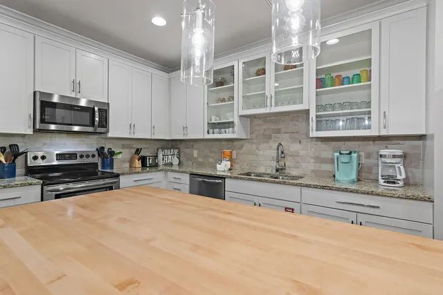 a kitchen with stainless steel appliances granite countertop a stove and cabinets