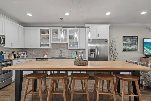 a kitchen with stainless steel appliances granite countertop a stove a refrigerator and a dining table