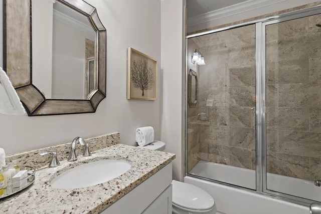 a bathroom with a granite countertop sink toilet and shower