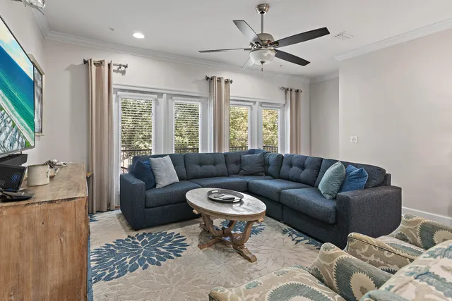 a living room with furniture a ceiling fan and a window