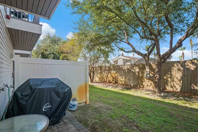 a view of backyard with barbeque and trees