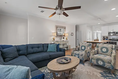 a living room with furniture a rug and kitchen view