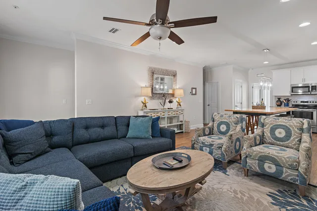 a living room with furniture a rug and kitchen view