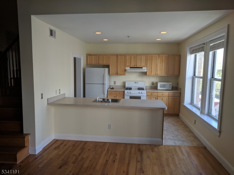 385 George Street, Unit 3B New Brunswick, NJ 08901 - Photo 13 of 18 a kitchen with stainless steel appliances granite countertop a stove a sink and a refrigerator