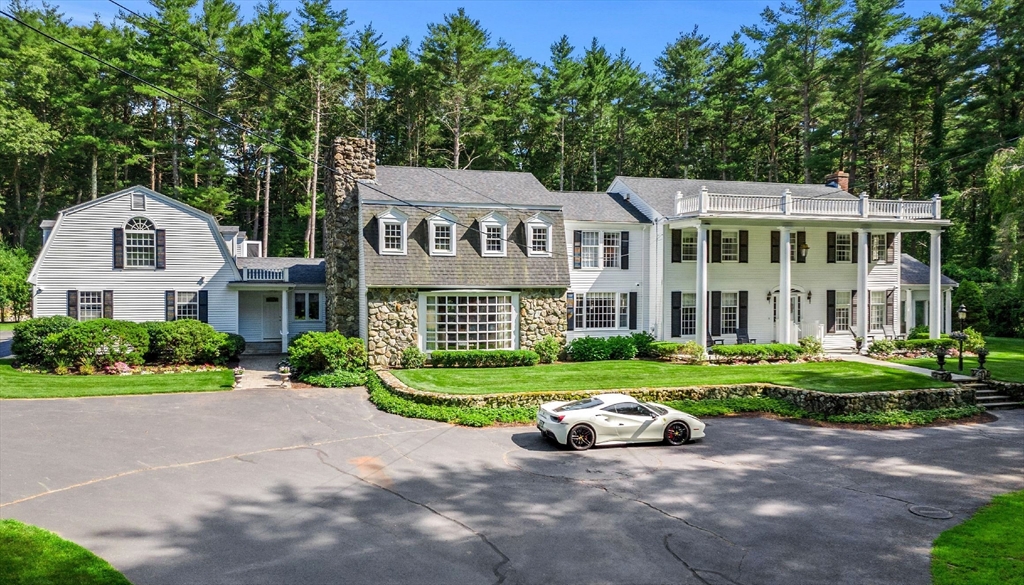 a view of a big house with a big yard and large trees