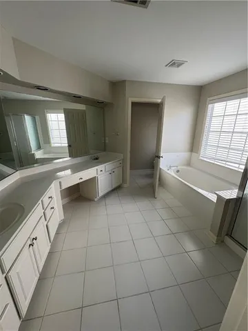a large white kitchen with a sink a toilet and granite counter tops