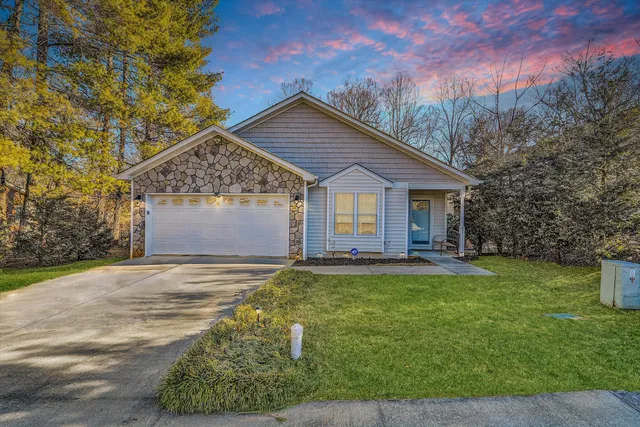 a view of a house with a yard and large tree