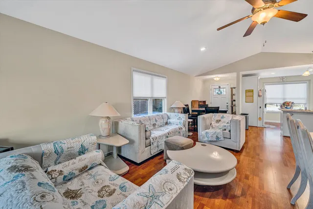 a living room with furniture and view of kitchen