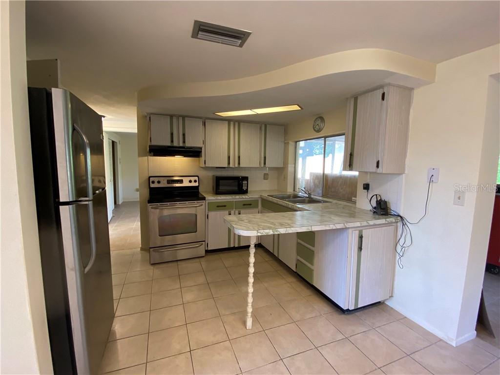 3612 Springfield Drive Holiday, FL 34691 - Photo 8 of 13 a kitchen with kitchen island granite countertop a stove refrigerator and cabinets