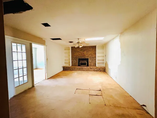 an empty room with fireplace and a window