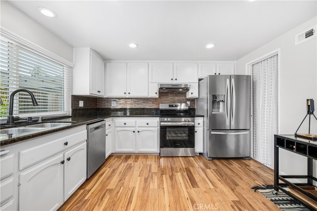 4237 Larwin Avenue Cypress, CA 90630 - Photo 14 of 48 a kitchen with stainless steel appliances granite countertop a refrigerator stove and sink