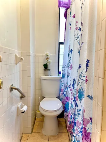 a white toilet sitting next to a shower curtain