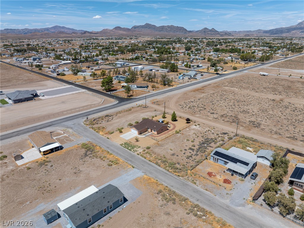 2970 Rio Rico Drive Pahrump, NV 89048 - Photo 37 of 41 Aerial view reveals a quiet desert neighborhood set against a backdrop of distant rugged mountains.