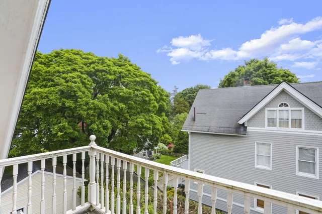 a view of a house with a yard and potted plants