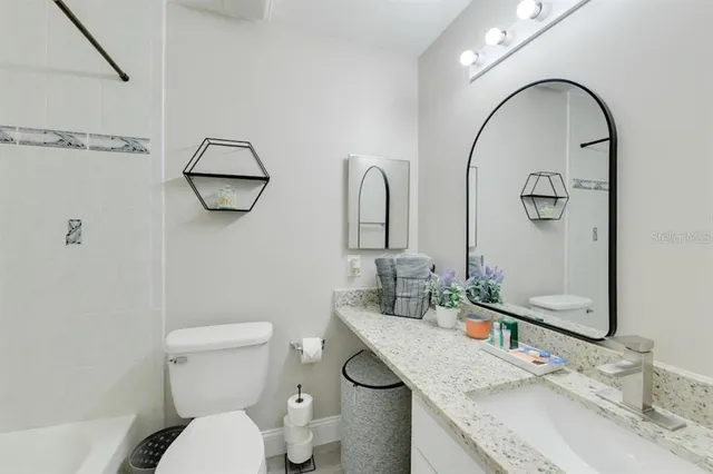 a view of a house with a yard and a large tree