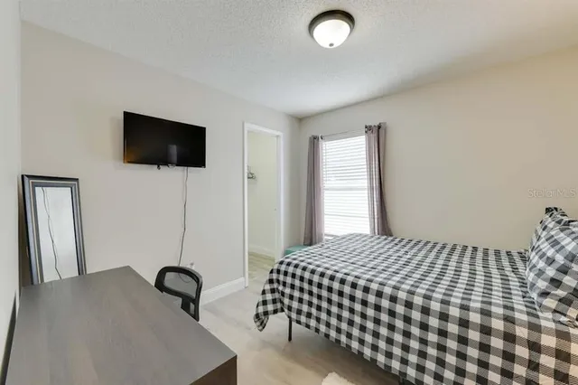 a living room with a bed furniture and a flat screen tv