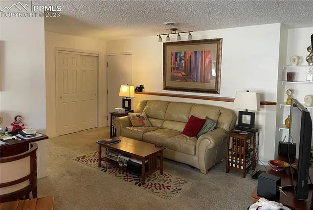 a living room with furniture a flat screen tv and a wall painting