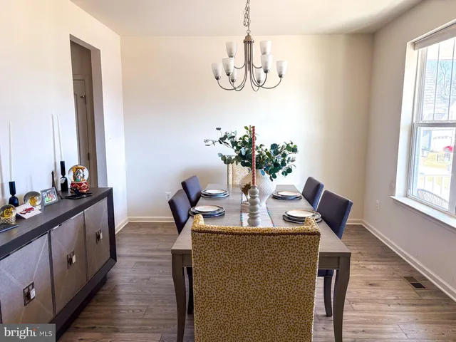 a view of dining room and livingroom with furniture wooden floor a chandelier