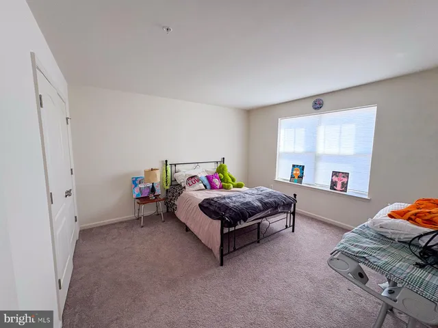 a bathroom with a granite countertop toilet a sink a mirror a window and a shower