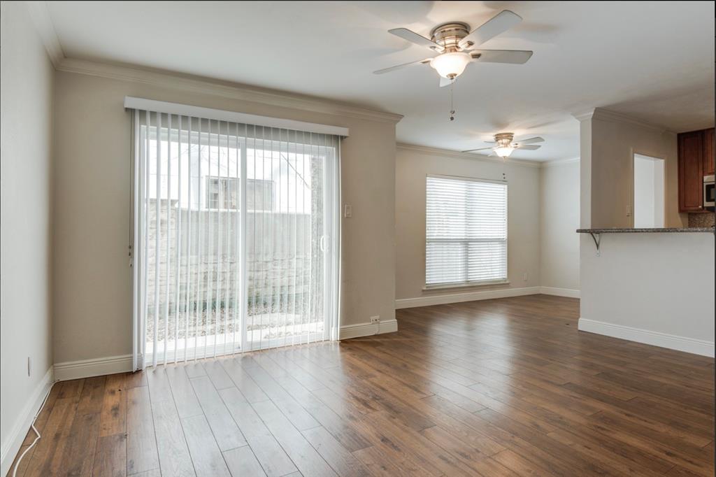 3907 Gilbert Avenue, Unit 3 Dallas, TX 75219 - Photo 3 of 9 a view of an empty room with wooden floor and a window