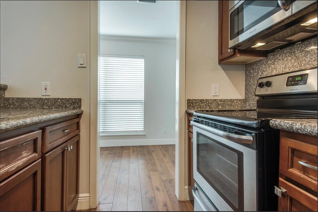 3907 Gilbert Avenue, Unit 3 Dallas, TX 75219 - Photo 6 of 9 a kitchen with granite countertop a stove and a microwave