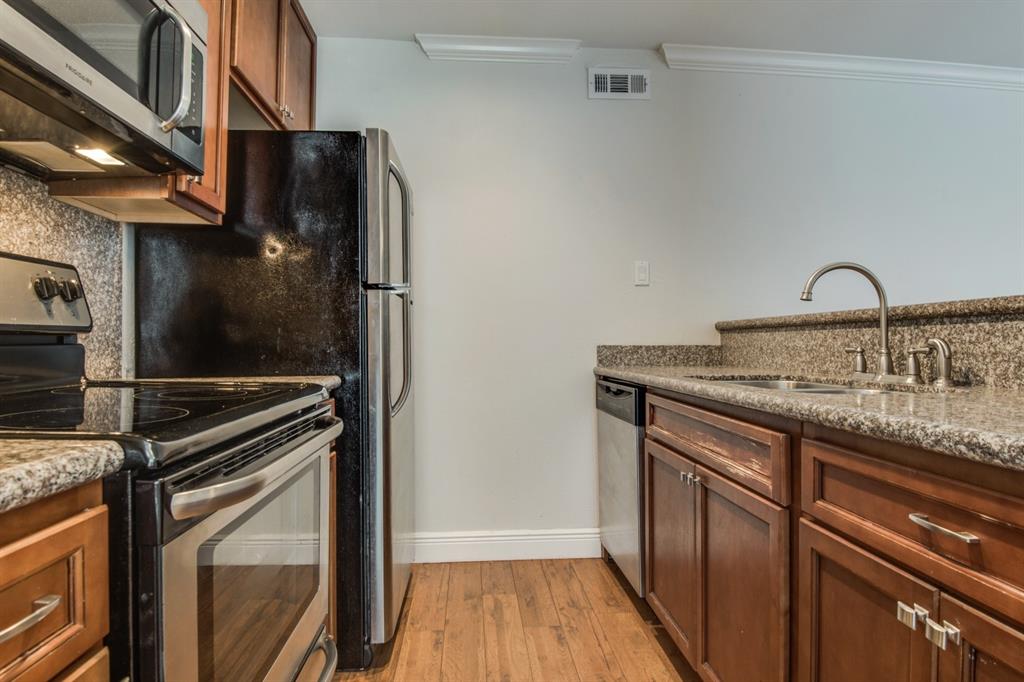 3907 Gilbert Avenue, Unit 3 Dallas, TX 75219 - Photo 7 of 9 a kitchen with granite countertop a sink stove and refrigerator