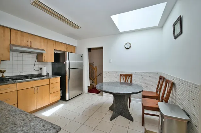 a kitchen with stainless steel appliances granite countertop a table chairs and a refrigerator