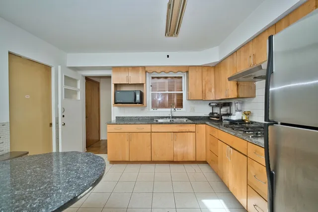 a kitchen with stainless steel appliances granite countertop a refrigerator and a sink